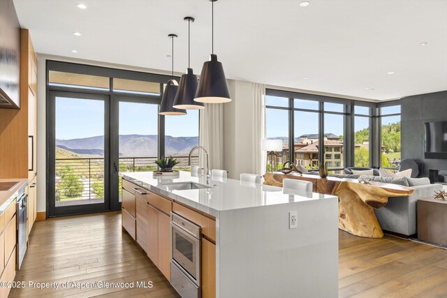 77 Wood Rd Unit 507-13, Snowmass Village, CO 81615 - kitchen with modern cabinets, a sink, light wood finished floors, a center island with sink, and recessed lighting