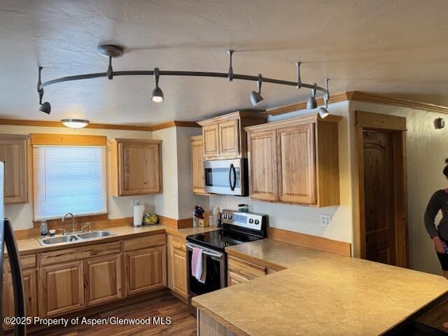763 Tucker St, Craig, CO 81625 - kitchen with stainless steel appliances, a peninsula, light countertops, dark wood-style flooring, and ornamental molding