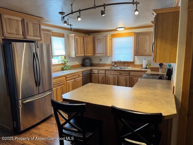 763 Tucker St, Craig, CO 81625 - kitchen featuring freestanding refrigerator, a peninsula, dishwashing machine, stove, and a breakfast bar area