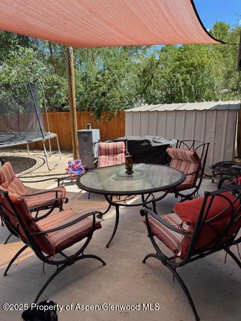 763 Tucker St, Craig, CO 81625 - fenced backyard with a trampoline, outdoor dining area, and a patio