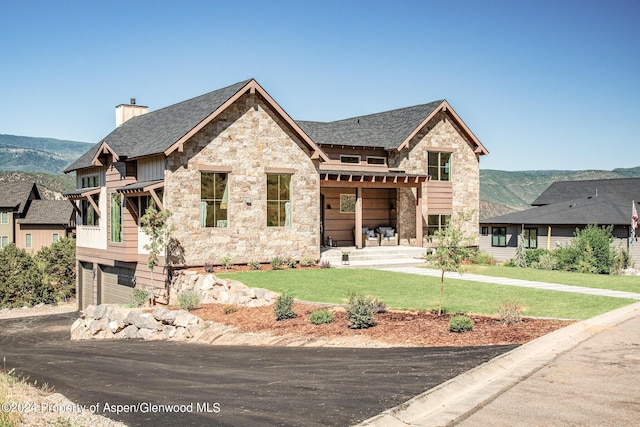 view of front of property with a mountain view, a garage, and a front yard