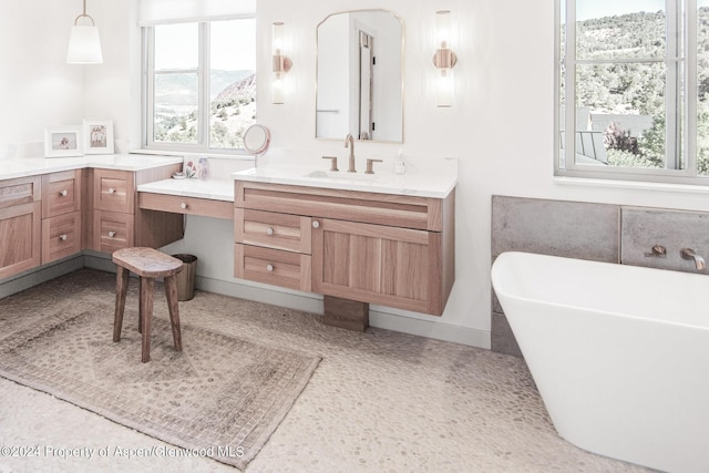 bathroom with a bathtub, a mountain view, and vanity