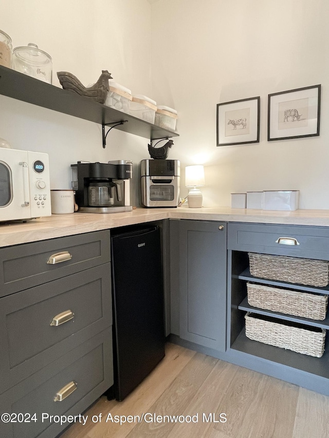 kitchen with light wood-type flooring and fridge