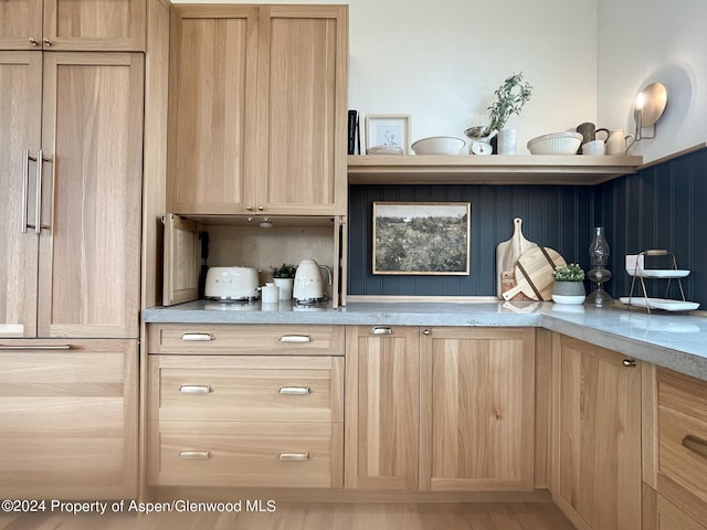 kitchen with decorative backsplash, paneled built in refrigerator, light stone countertops, and light brown cabinets