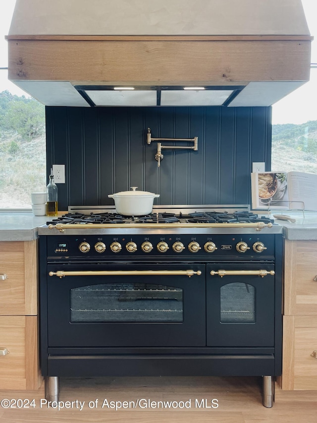 kitchen with double oven range and blue cabinetry