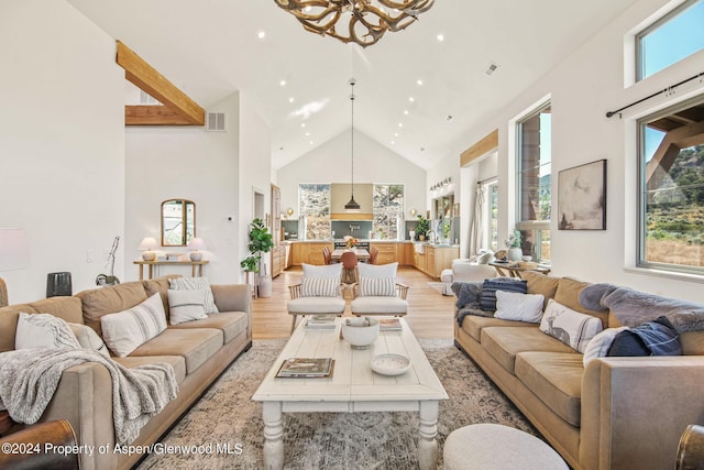 living room featuring light wood-type flooring, high vaulted ceiling, and plenty of natural light