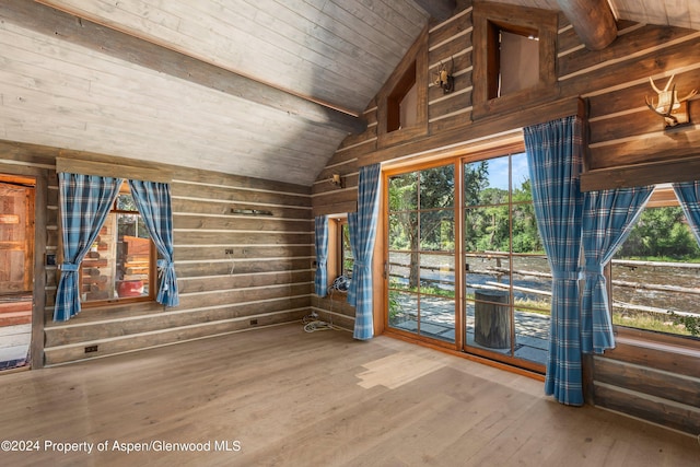 spare room featuring beam ceiling, wooden walls, wood ceiling, and wood-type flooring