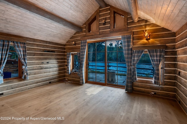 unfurnished room with hardwood / wood-style floors, vaulted ceiling with beams, wood ceiling, and wooden walls