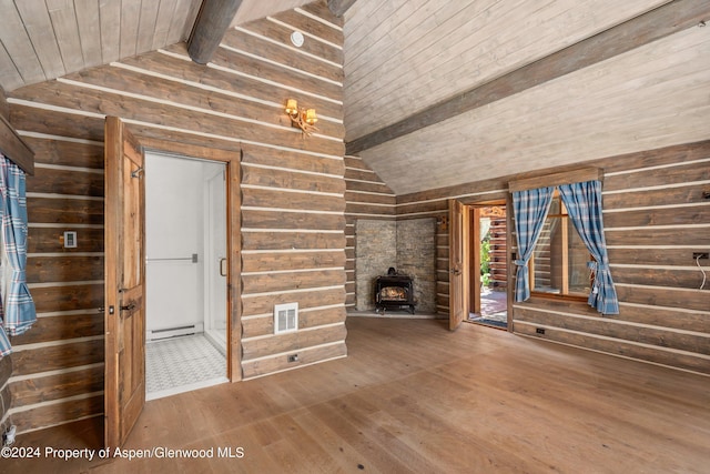 unfurnished living room featuring a baseboard heating unit, wooden ceiling, beamed ceiling, hardwood / wood-style floors, and a wood stove