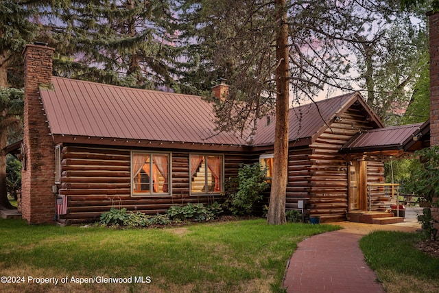 log-style house featuring a lawn