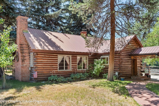 rear view of property featuring a lawn