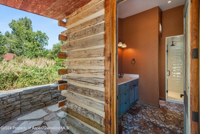 exterior space with vanity, plenty of natural light, and a shower with shower door