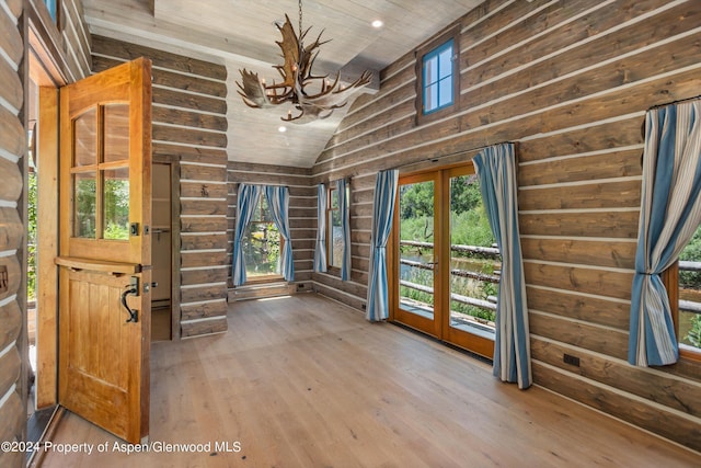 entryway with hardwood / wood-style floors, an inviting chandelier, vaulted ceiling, rustic walls, and wood ceiling