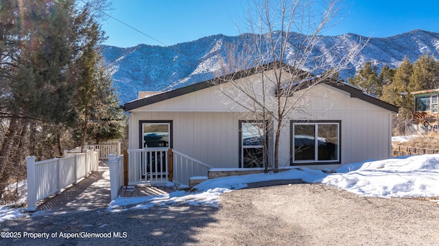 snow covered back of property with a mountain view