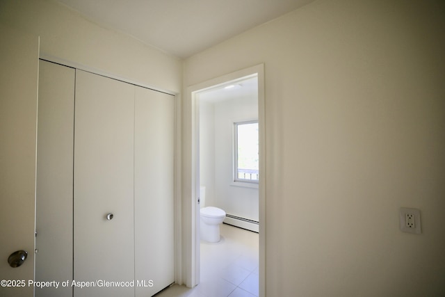 hall featuring a baseboard radiator and light tile patterned floors