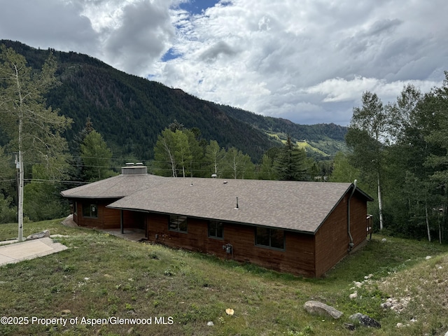 exterior space with a mountain view and a lawn