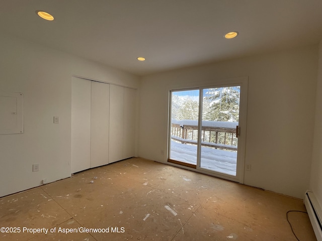 interior space with access to exterior, electric panel, a closet, and a baseboard heating unit