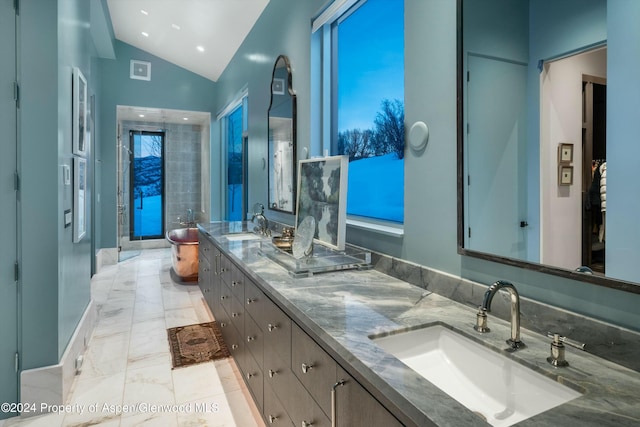 bathroom with vanity, vaulted ceiling, and walk in shower