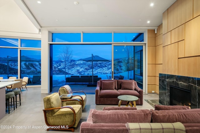 living room with a mountain view, a wall of windows, and a fireplace