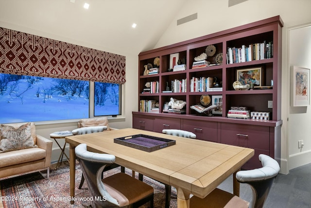 dining room featuring built in features, dark wood-type flooring, and vaulted ceiling