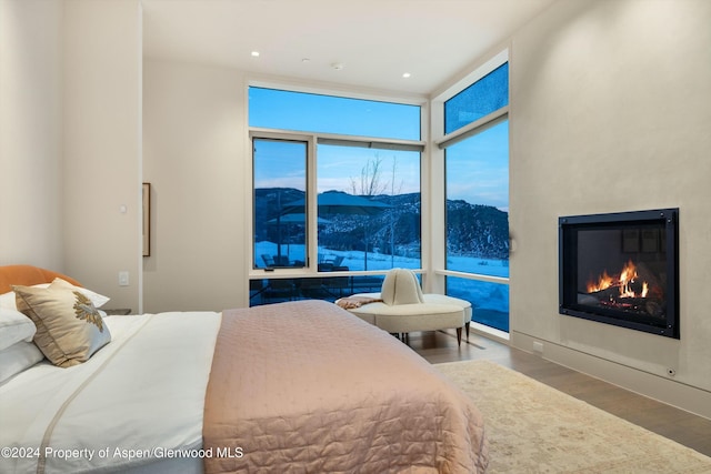 bedroom with a mountain view, hardwood / wood-style flooring, and floor to ceiling windows