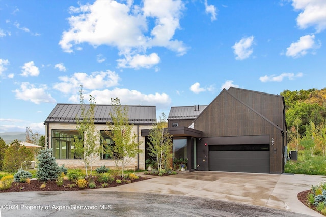 387 Branding Ln, Snowmass Village, CO 81615 - contemporary house featuring a standing seam roof, a garage, driveway, and a metal roof