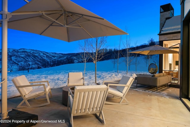 snow covered patio with a mountain view