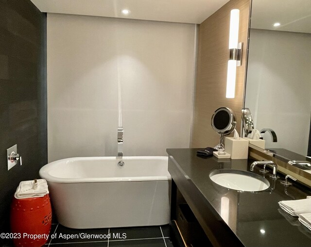 bathroom featuring a washtub, vanity, and tile patterned flooring