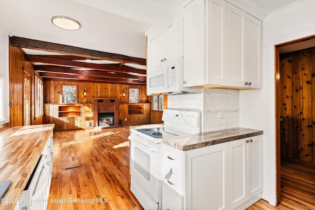 kitchen with white cabinetry, beamed ceiling, white appliances, and wood counters