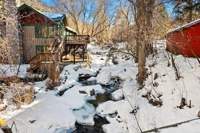 snowy yard with a wooden deck