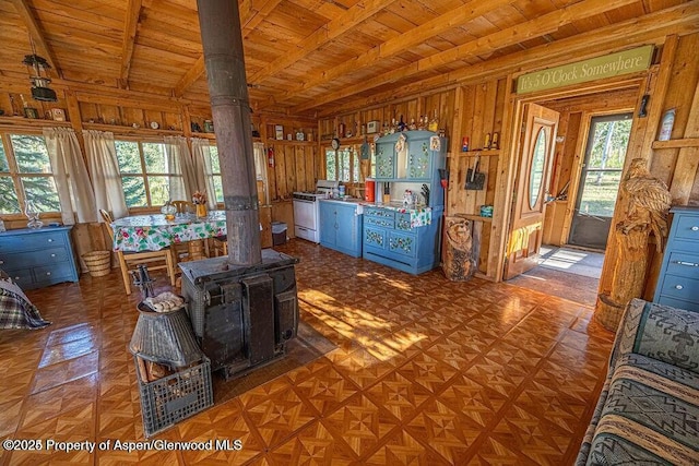 1136 Dipper Dr, Craig, CO 81625 - living area featuring wooden ceiling with exposed beams, a wood stove, and healthy amount of natural light