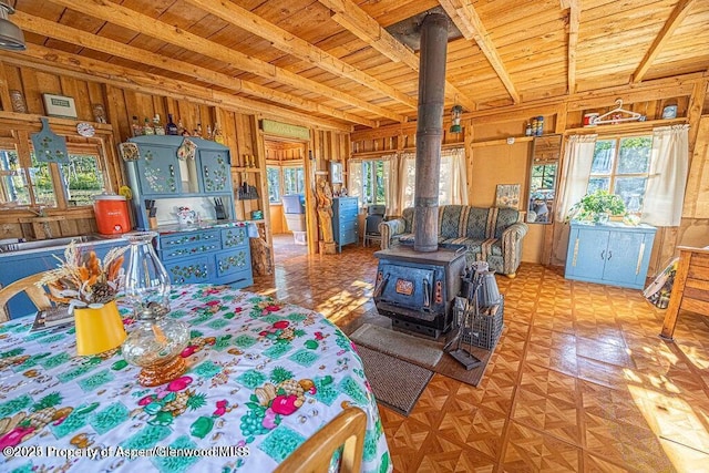 1136 Dipper Dr, Craig, CO 81625 - dining space with wooden ceiling with exposed beams, a wood stove, a wall mounted air conditioner, and wooden walls