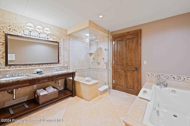 bathroom with plus walk in shower, tile patterned flooring, tile walls, and double sink