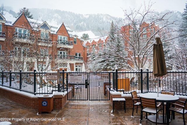 snow covered patio featuring a mountain view