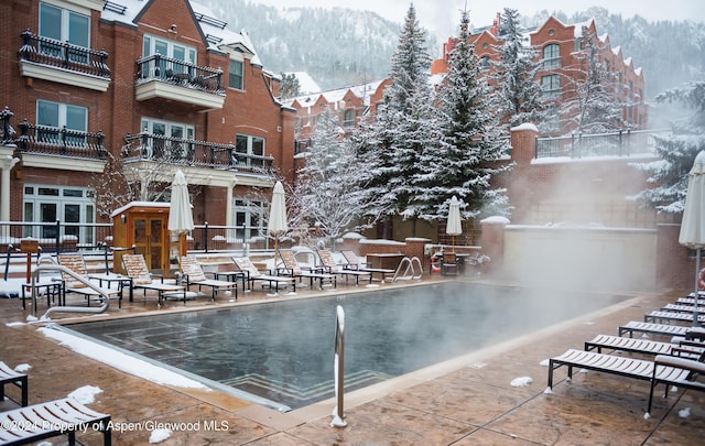 snow covered pool featuring a mountain view