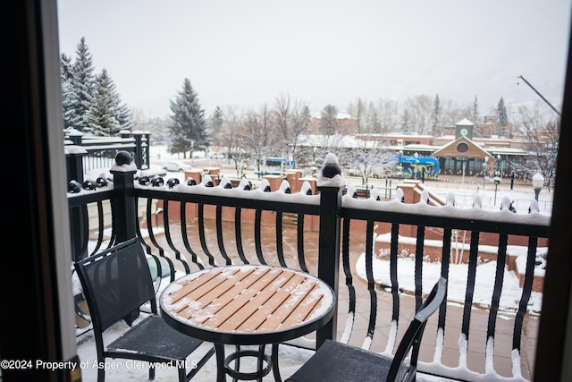 view of snow covered back of property