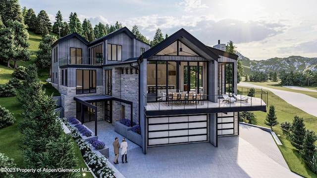 rear view of property with a mountain view, a balcony, and a garage