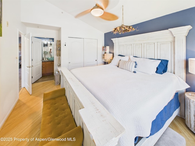 bedroom featuring a ceiling fan, light wood-style floors, a closet, and vaulted ceiling