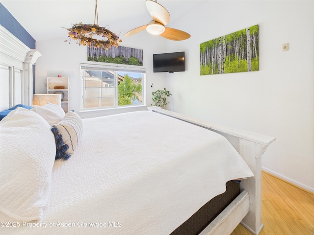 bedroom with baseboards, multiple windows, and wood finished floors