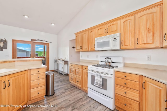 1600 County Road 30, Craig, CO 81625 - kitchen with white appliances, lofted ceiling, light brown cabinets, light wood-type flooring, and light countertops