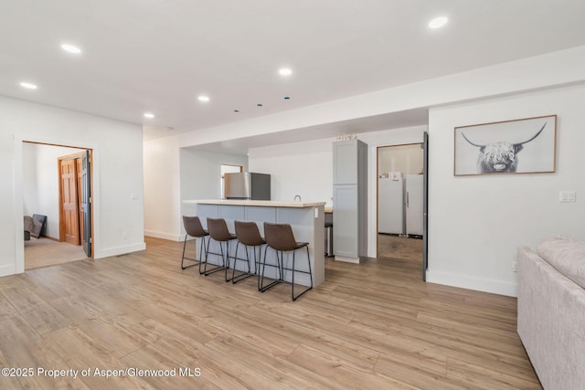 1600 County Road 30, Craig, CO 81625 - kitchen featuring a kitchen breakfast bar, open floor plan, freestanding refrigerator, recessed lighting, and light wood-type flooring