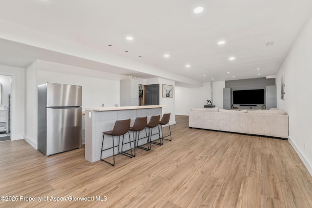 1600 County Road 30, Craig, CO 81625 - kitchen with freestanding refrigerator, light wood-style flooring, a breakfast bar area, baseboards, and recessed lighting
