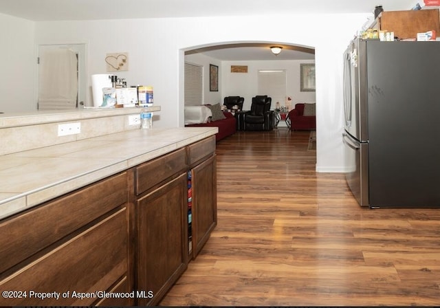 kitchen with dark hardwood / wood-style flooring and stainless steel refrigerator