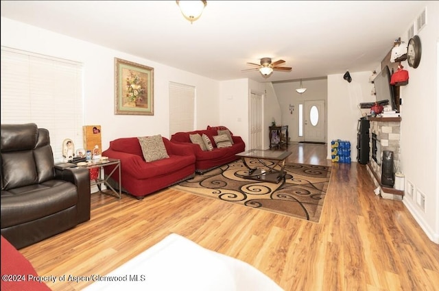 living room with a fireplace, hardwood / wood-style flooring, and ceiling fan