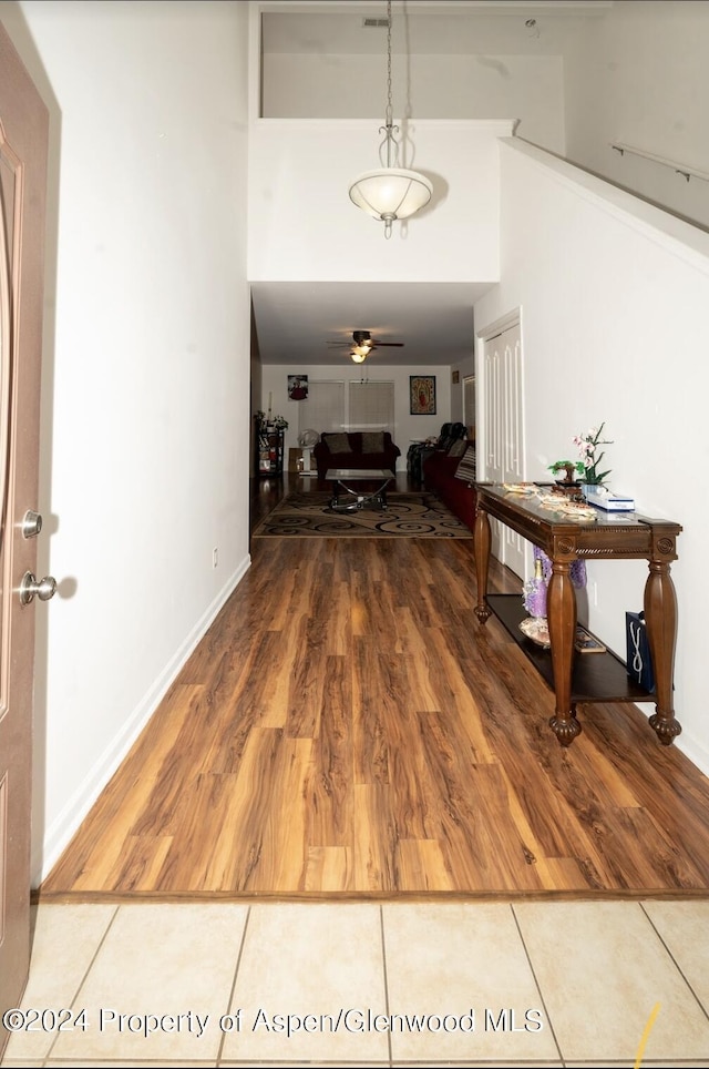 hallway with tile patterned flooring and a towering ceiling