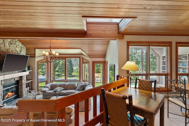 interior space featuring wood ceiling, a stone fireplace, and a notable chandelier