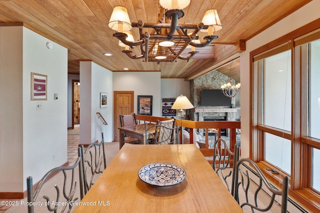 dining area with an inviting chandelier, wood ceiling, and a stone fireplace