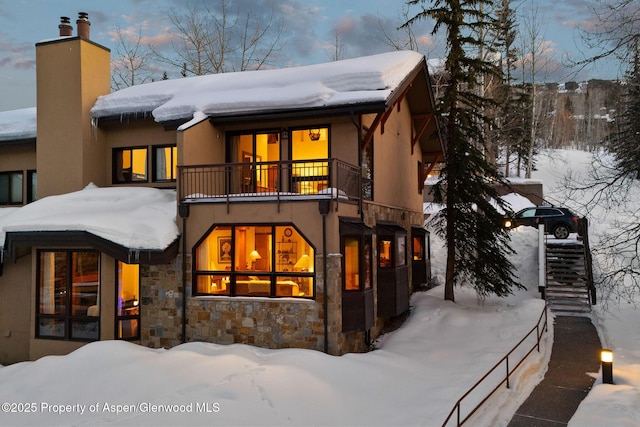 snow covered property featuring a balcony