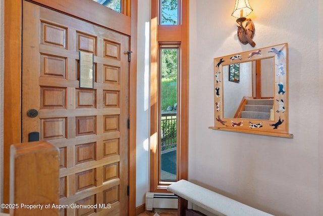 foyer entrance featuring baseboard heating and a healthy amount of sunlight