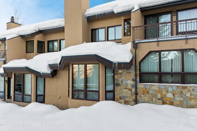 view of snow covered rear of property